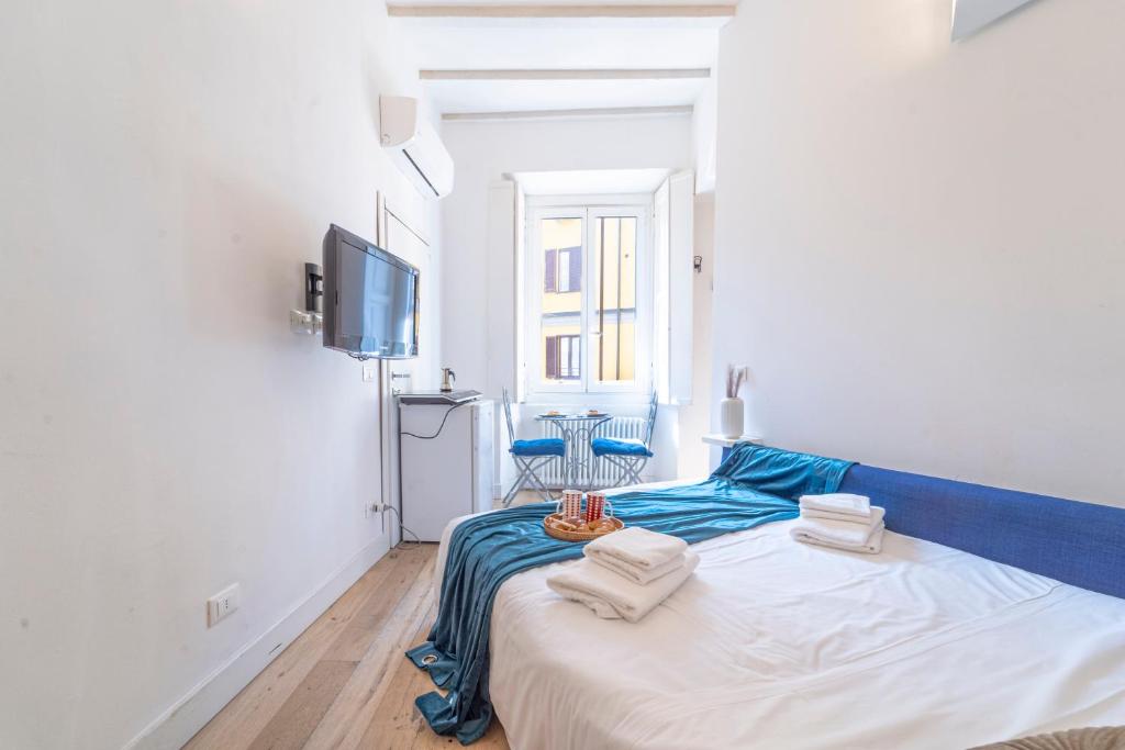 a white and blue bedroom with a bed and a tv at Luxury Studio in Porta Romana - Romano 15 in Milan