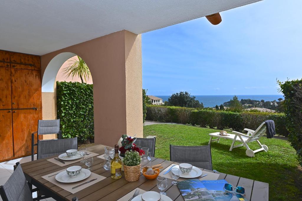 - une table en bois avec de la nourriture au-dessus d'une terrasse dans l'établissement Anémone, à Saint-Raphaël