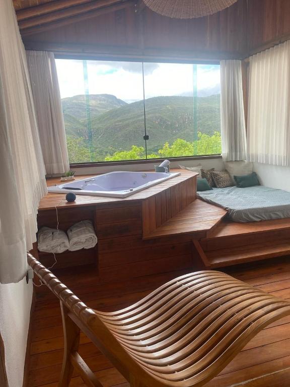 a bath tub in a room with a large window at Reserva Cipó in Serra do Cipo