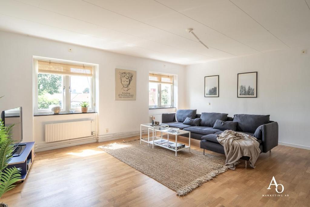 a living room with a blue couch and a table at Apartment in Österlen in Skillinge