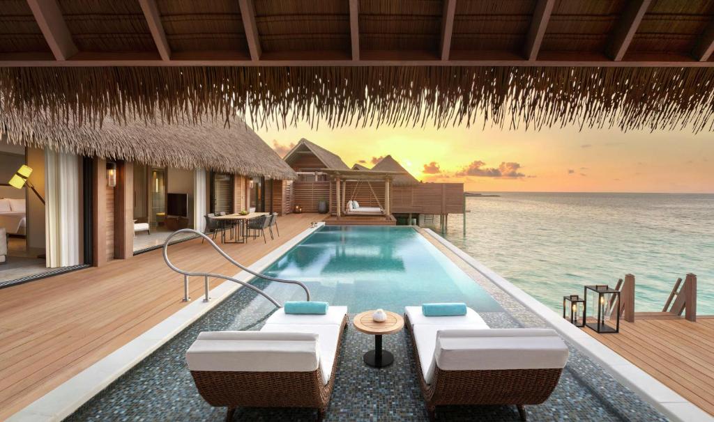 a villa with a swimming pool in the ocean at Waldorf Astoria Maldives Ithaafushi in South Male Atoll