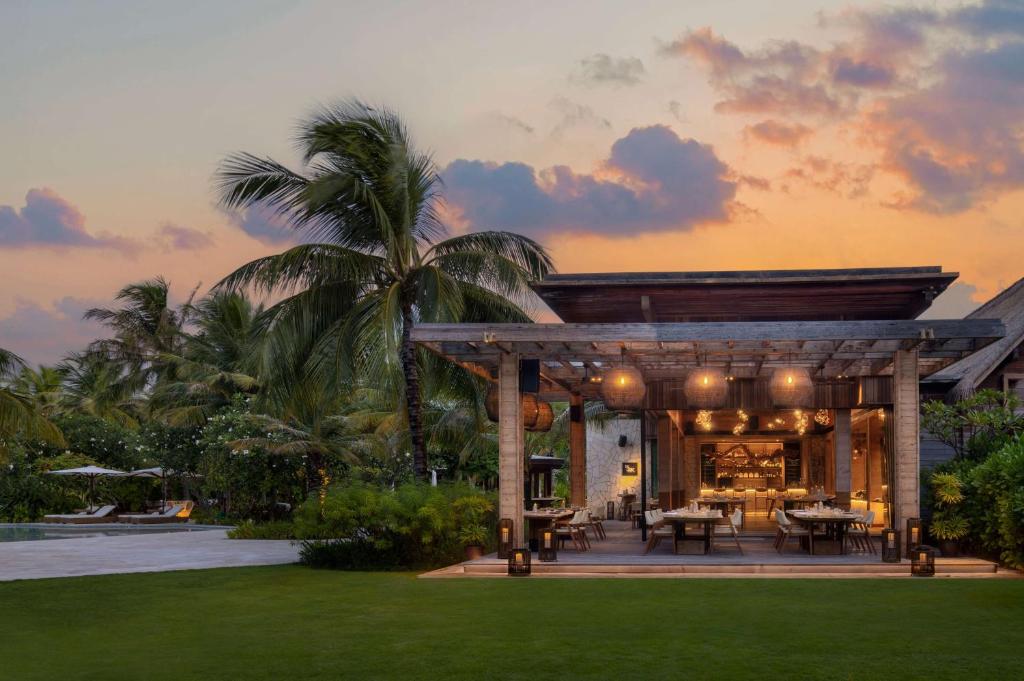 a villa with a pavilion in the middle of a lawn at Waldorf Astoria Maldives Ithaafushi in South Male Atoll