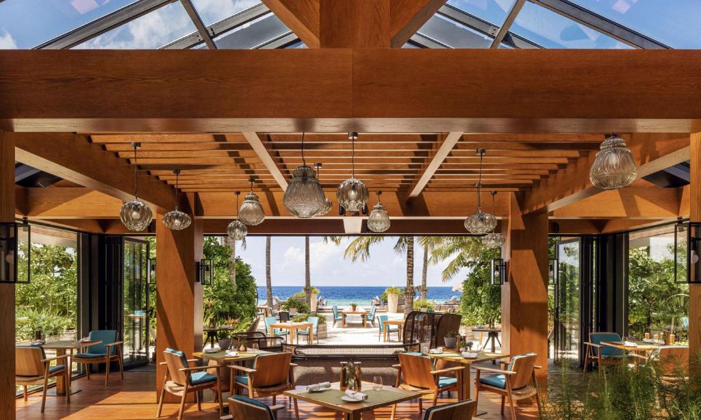 a restaurant with a view of the ocean at Waldorf Astoria Maldives Ithaafushi in South Male Atoll
