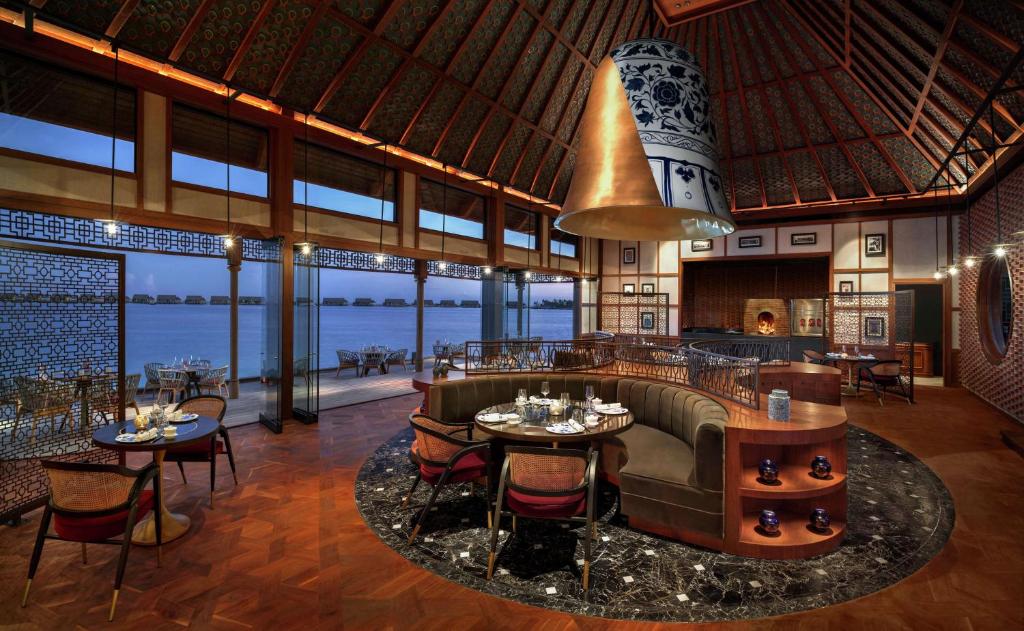 a restaurant with a view of the ocean at Waldorf Astoria Maldives Ithaafushi in South Male Atoll