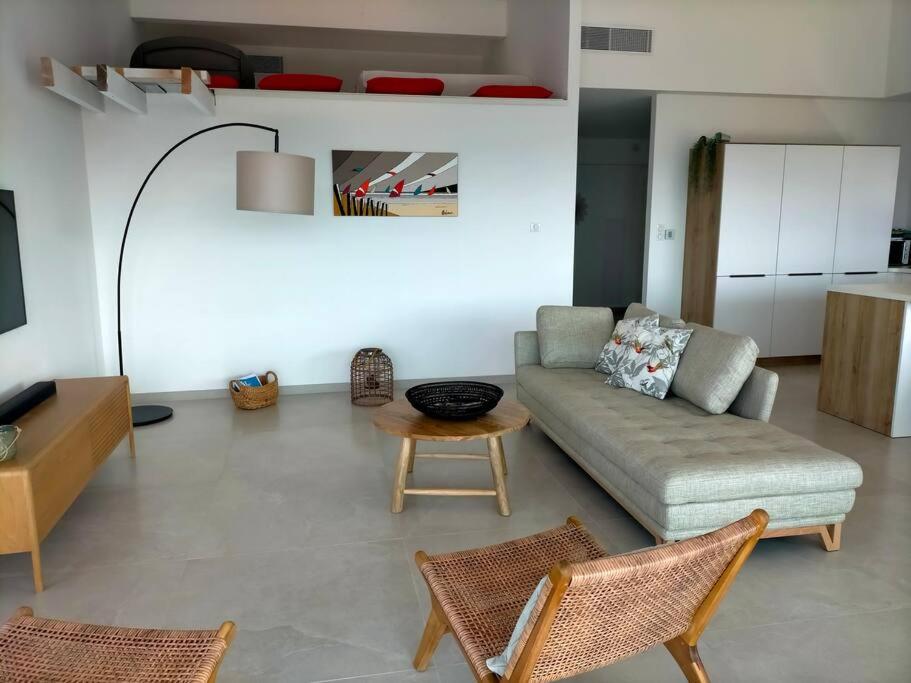 un salon avec un canapé, une table et des chaises dans l'établissement vue mer époustouflante plage village à pied, à Hyères