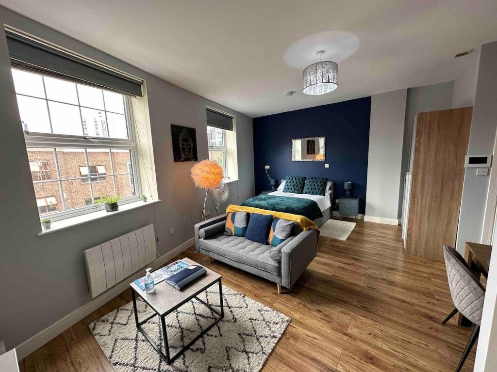 a living room with a bed and a couch at Spacious and homely city centre studio in Coventry