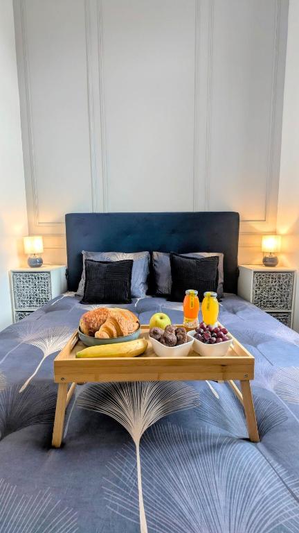 - un plateau de nourriture sur un lit avec deux verres de jus d'orange dans l'établissement L'haussmannien 1er Étage, à Abbeville