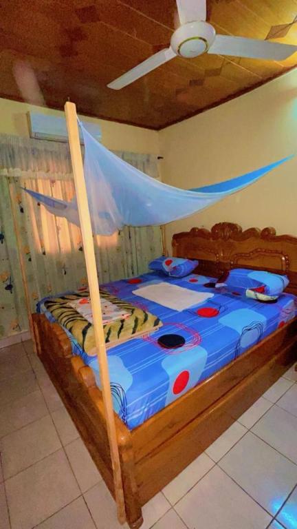 a wooden bed in a room with a ceiling at AG appart'hôtel villas in Ouagadougou