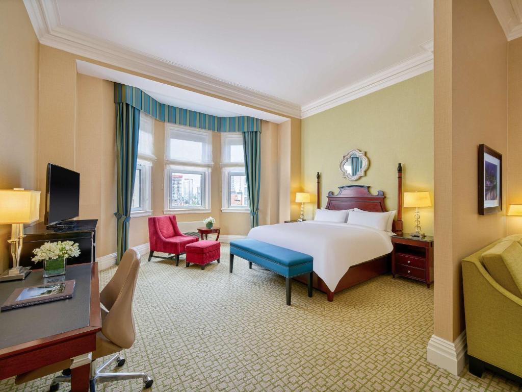 a large hotel room with a bed and a television at Fairmont Chateau Laurier in Ottawa