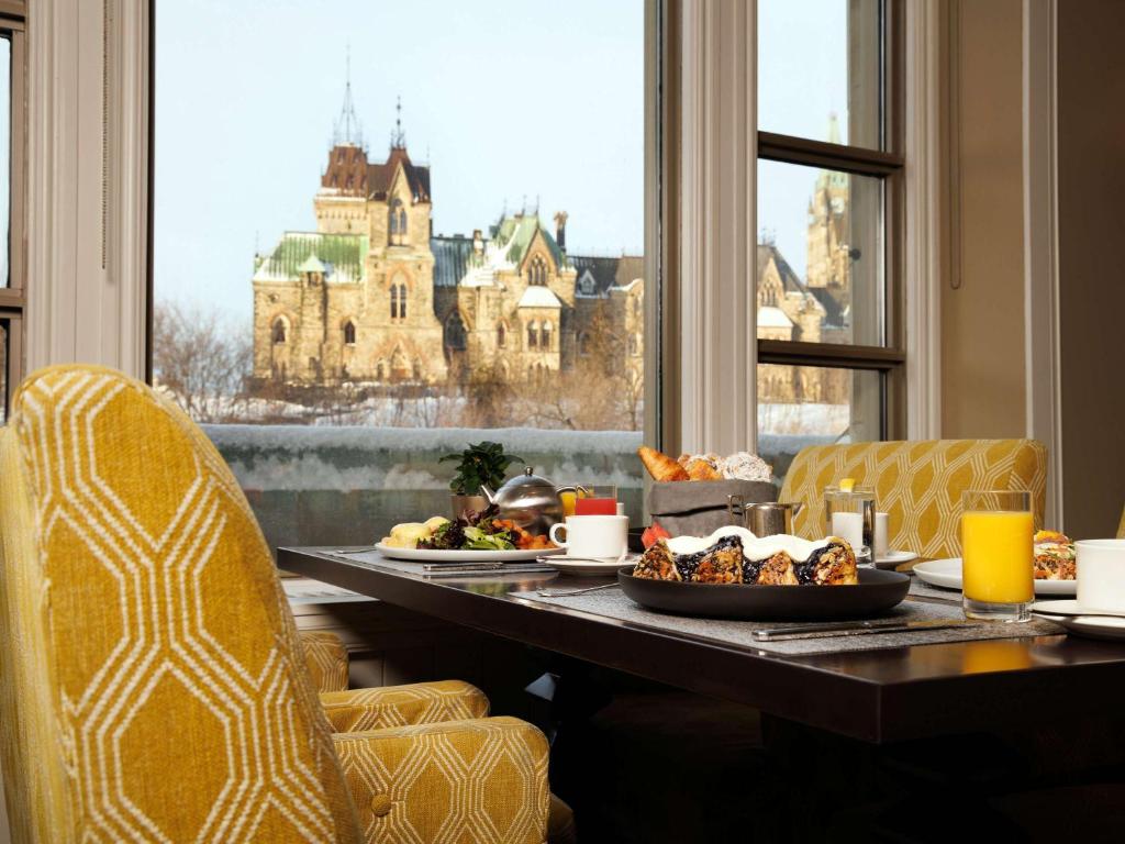 a breakfast table with food and a view of a castle at Fairmont Chateau Laurier in Ottawa