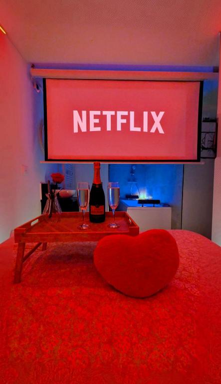 un cœur rouge assis sur une table avec des verres à vin dans l'établissement Love nest 1er Étage, à Abbeville