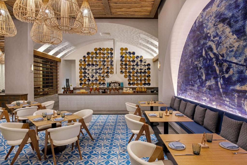 a restaurant with tables and chairs and a counter at Conrad Tulum Riviera Maya in Tulum