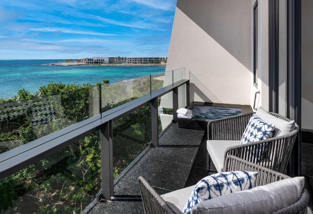 a balcony with chairs and a view of the ocean at Conrad Tulum Riviera Maya in Tulum