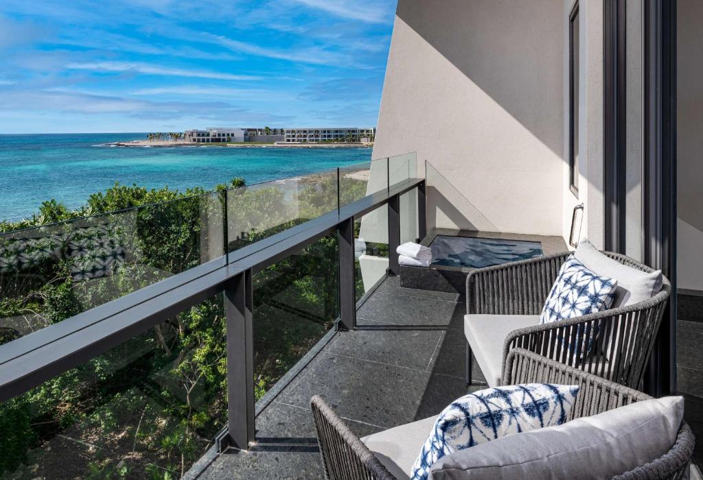 a balcony with chairs and a view of the ocean at Conrad Tulum Riviera Maya in Tulum