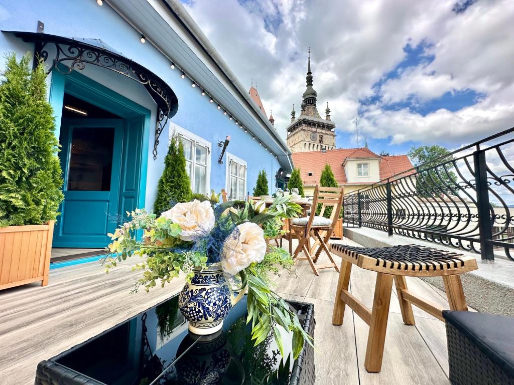 a balcony with a vase of flowers on a building at Casa Albastră by Casa Otto in Sighişoara