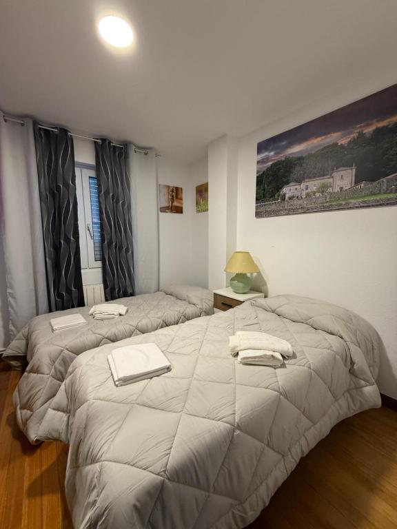 a bedroom with two beds with towels on them at Apartamento AJO 2 habitaciones piscina y tenis in Ajo