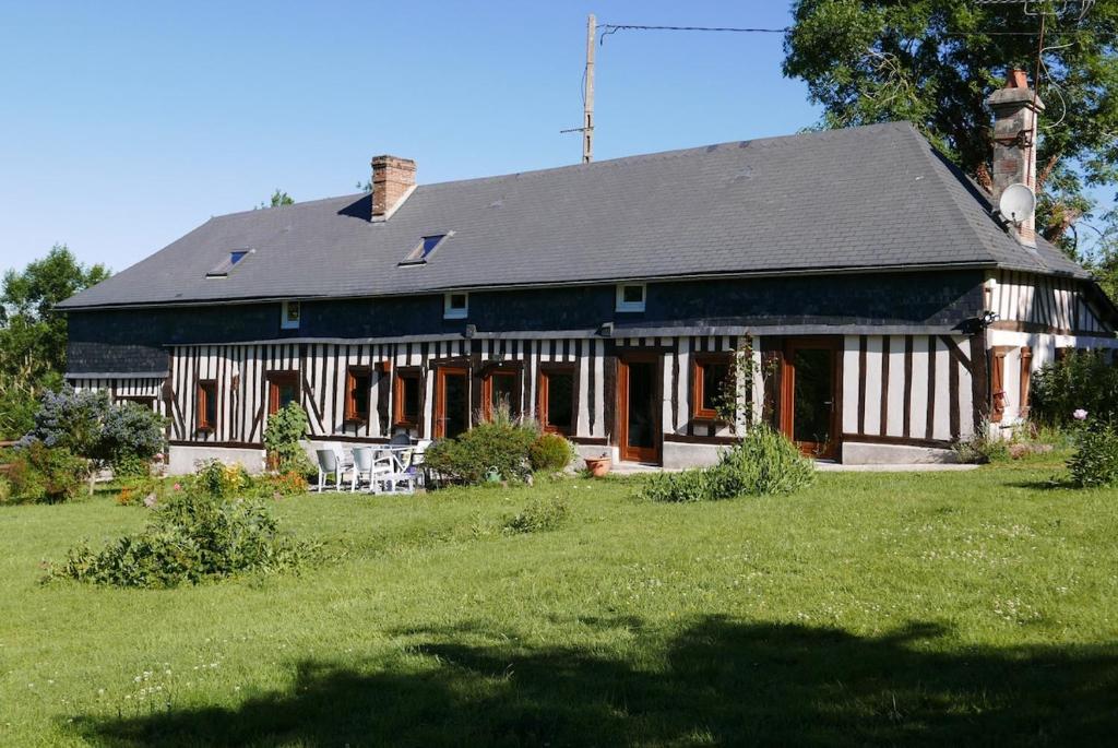 une grande maison sur un champ avec une cour verdoyante dans l'établissement La Petite Haie, à Bonneville-la-Louvet
