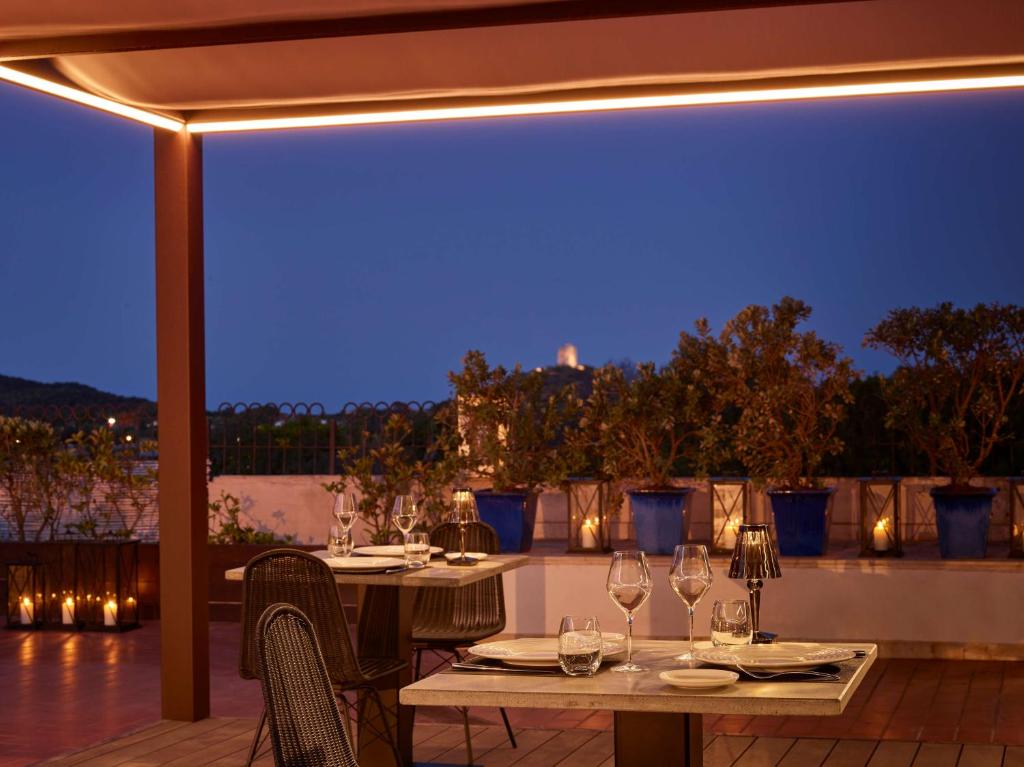 a table with wine glasses on a patio at night at Conrad Chia Laguna Sardinia in Chia
