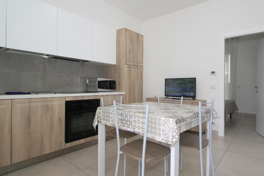 a kitchen with a table with chairs and a television at Regina Mare in Lido degli Scacchi