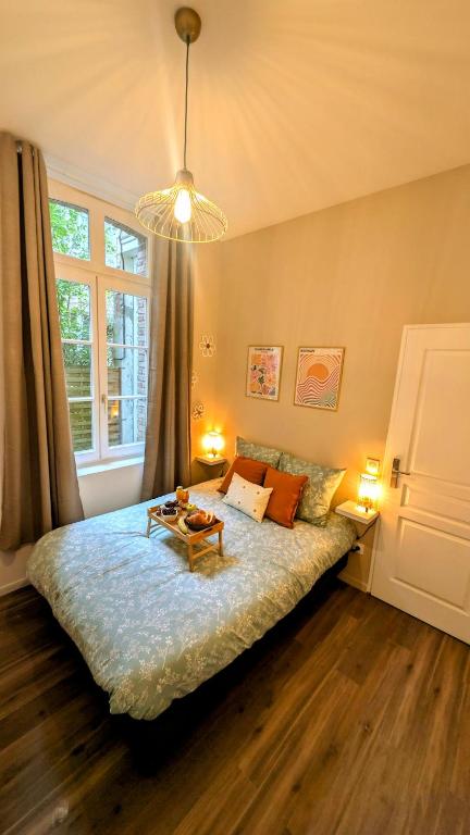 - une chambre avec un lit et une table dans l'établissement Le vintage RDC, à Abbeville