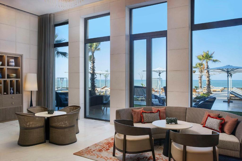 a hotel lobby with two tables and a couch at Conrad Rabat Arzana in Rabat