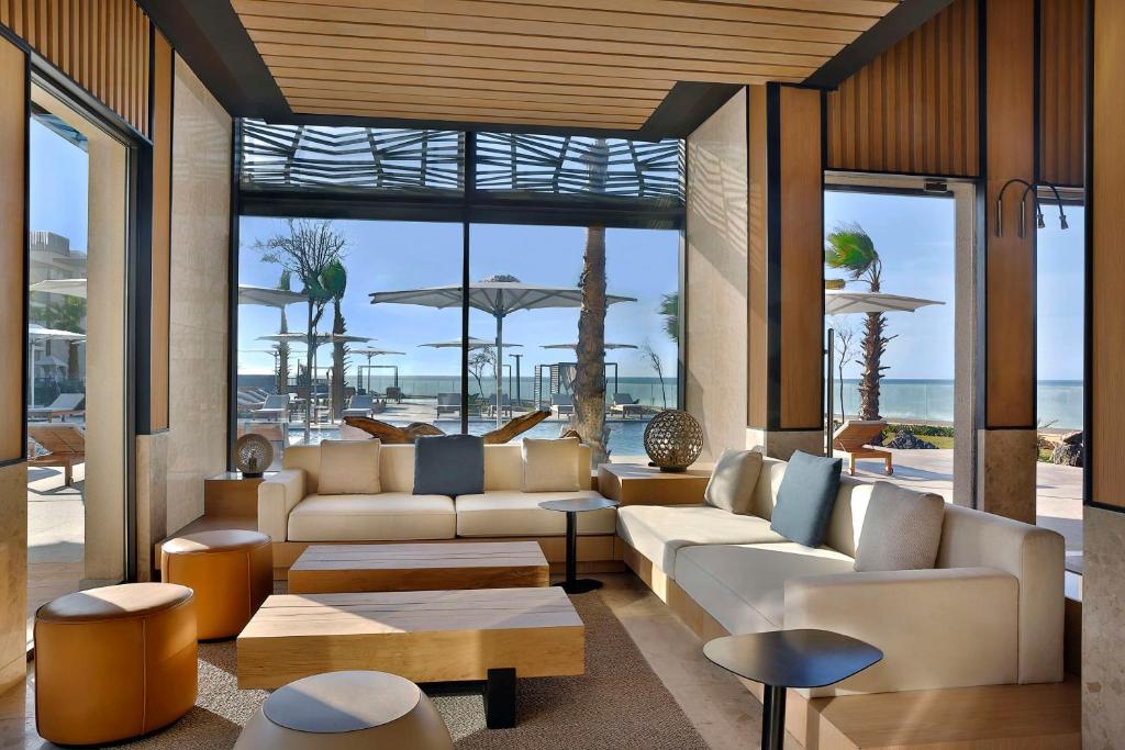a living room with couches and a view of the ocean at Conrad Rabat Arzana in Rabat