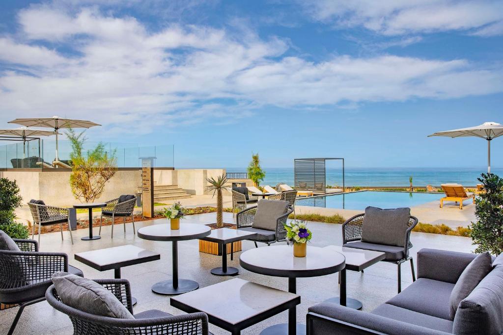 a patio with tables and chairs and a pool at Conrad Rabat Arzana in Rabat