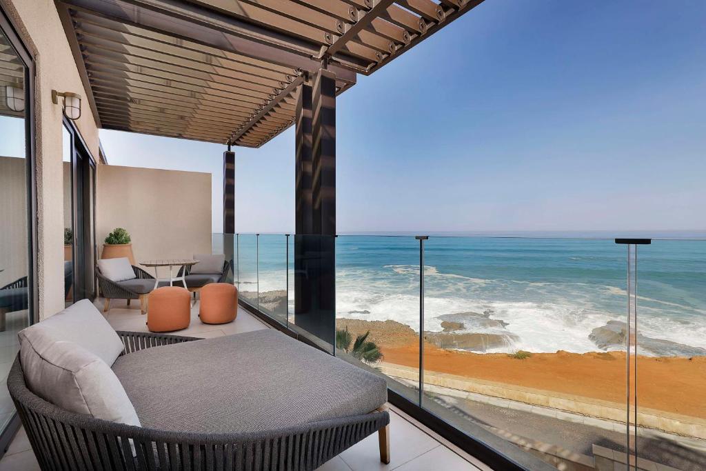 a balcony with a view of the ocean at Conrad Rabat Arzana in Rabat