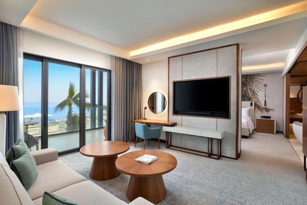 a hotel room with a large television and a living room at Conrad Rabat Arzana in Rabat