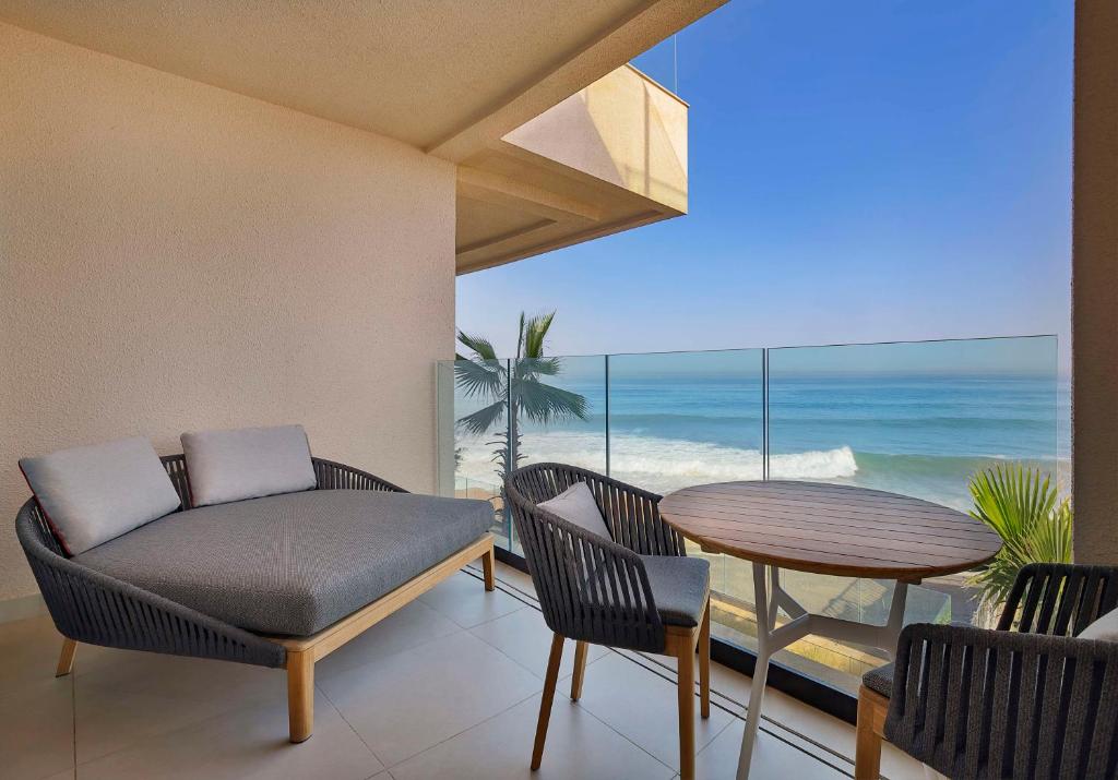 a living room with a table and chairs and the ocean at Conrad Rabat Arzana in Rabat