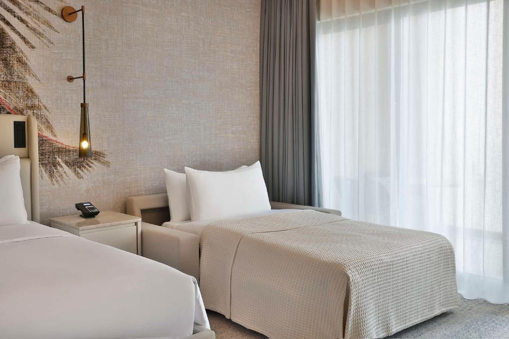 a hotel room with two beds and a window at Conrad Rabat Arzana in Rabat