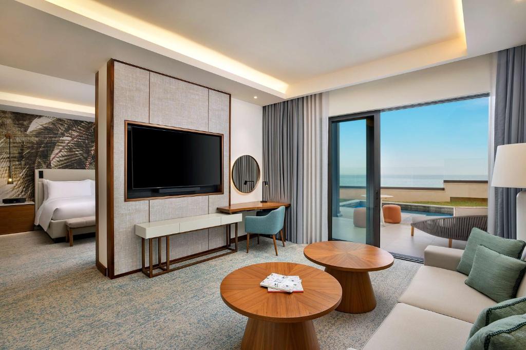 a living room with a television and a couch at Conrad Rabat Arzana in Rabat