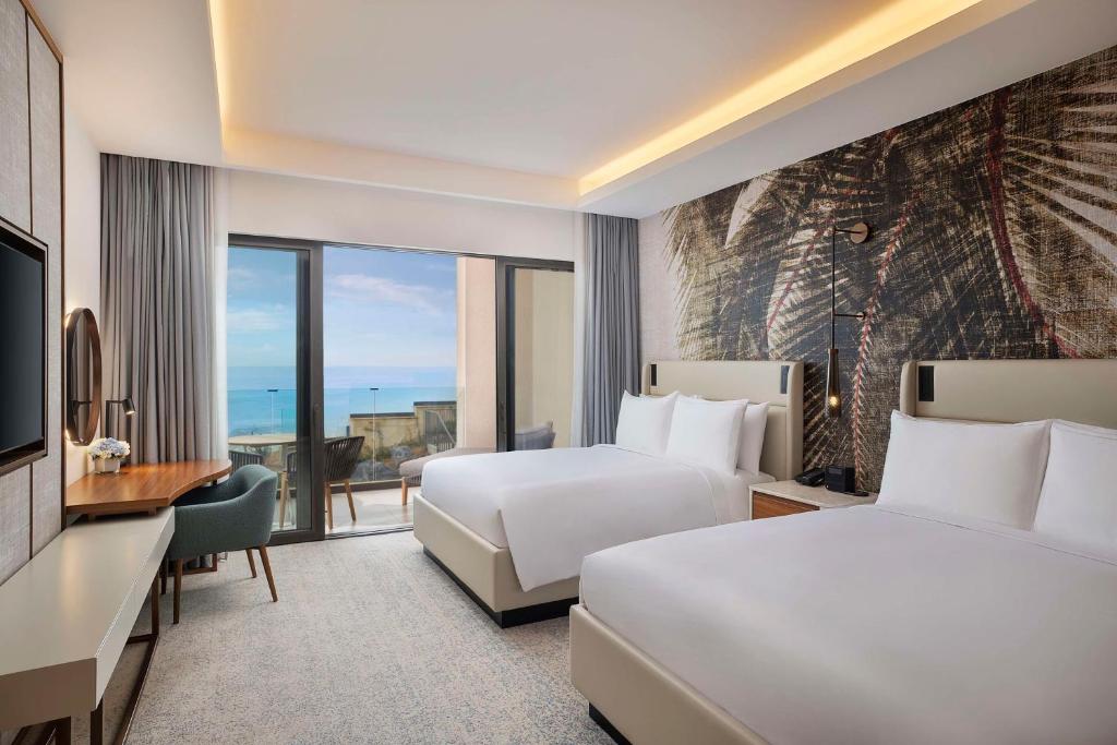 a hotel room with two beds and a television at Conrad Rabat Arzana in Rabat