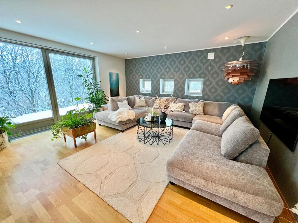a large living room with a couch and a table at Panorama Storelva in Tromsø