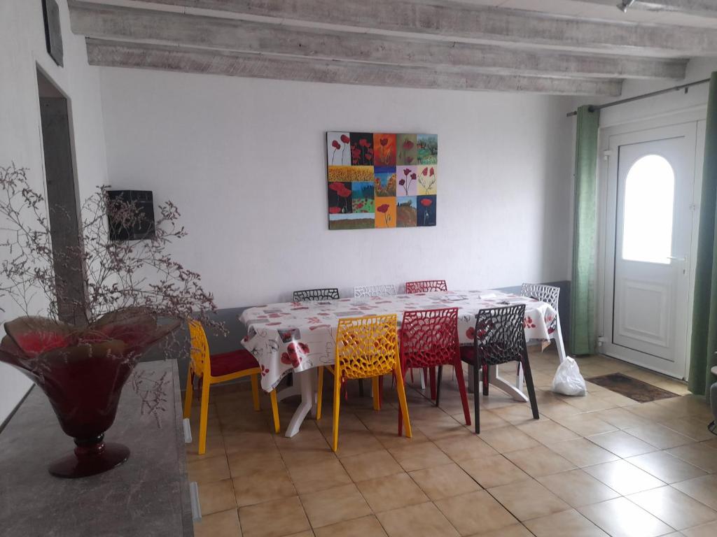 une salle à manger avec une table et des chaises colorées dans l'établissement Maison Joséphine, à Valras-Plage