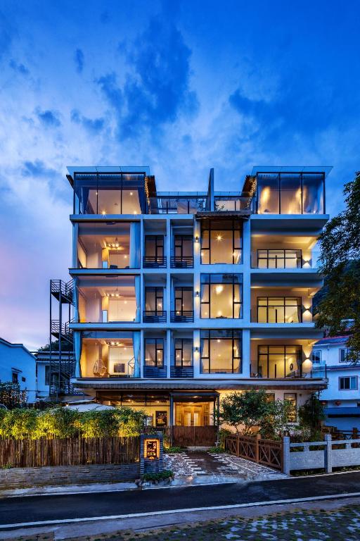 duży budynek z wieloma oknami o zmierzchu w obiekcie Kite Home Stay w mieście Yangshuo