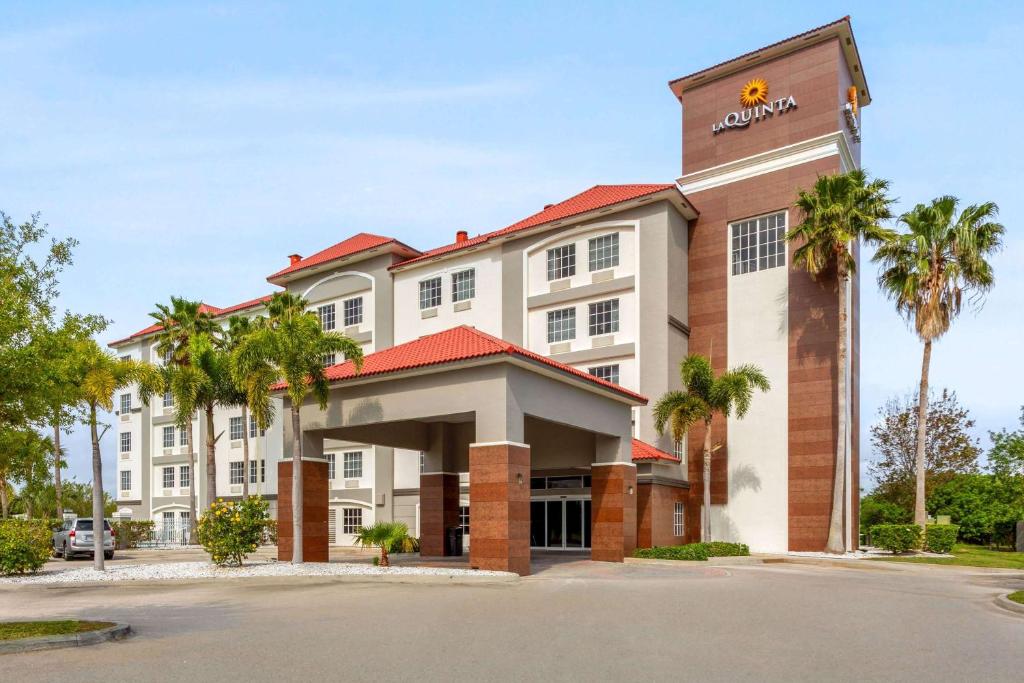 a hotel with palm trees in front of it at La Quinta by Wyndham Ft. Pierce in Fort Pierce