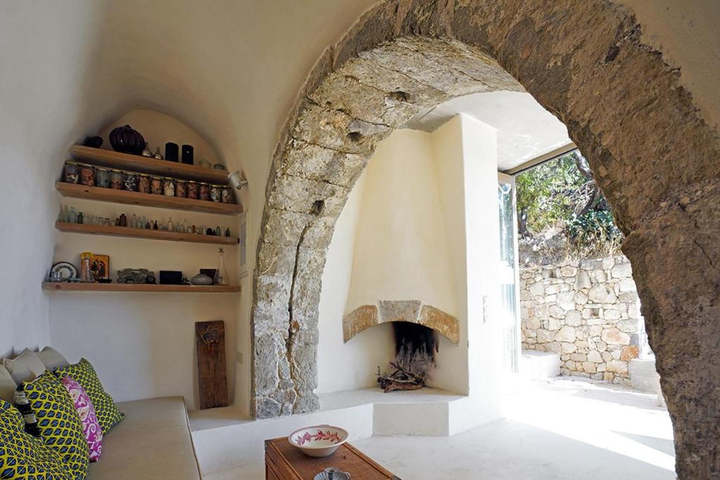 a living room with an archway and a fireplace at Paleopoli Cave House in Kythira