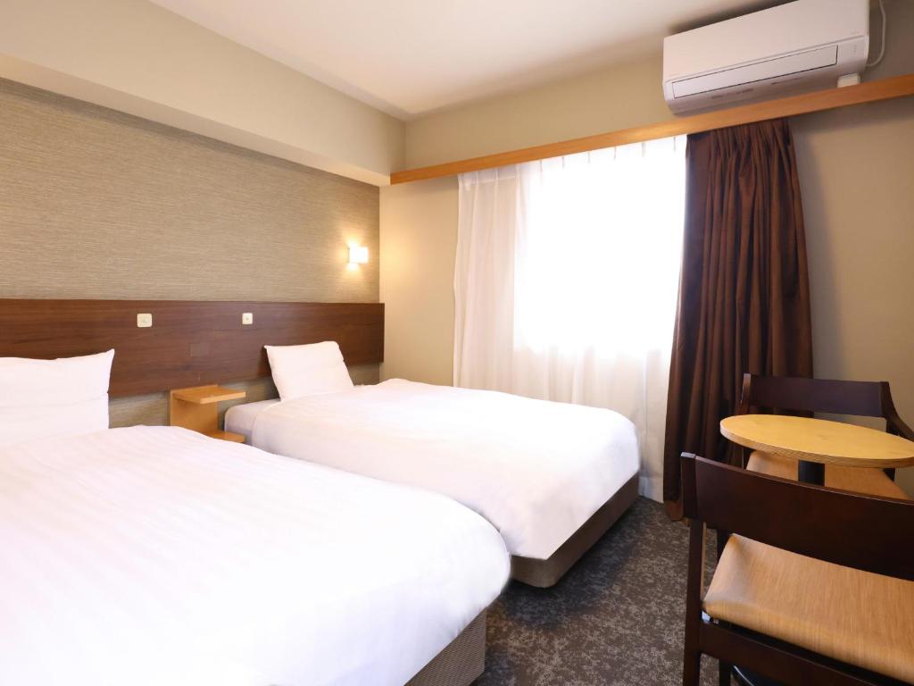 Postel nebo postele na pokoji v ubytování Tennen Onsen Taho-no-Yu Dormy Inn Niigata