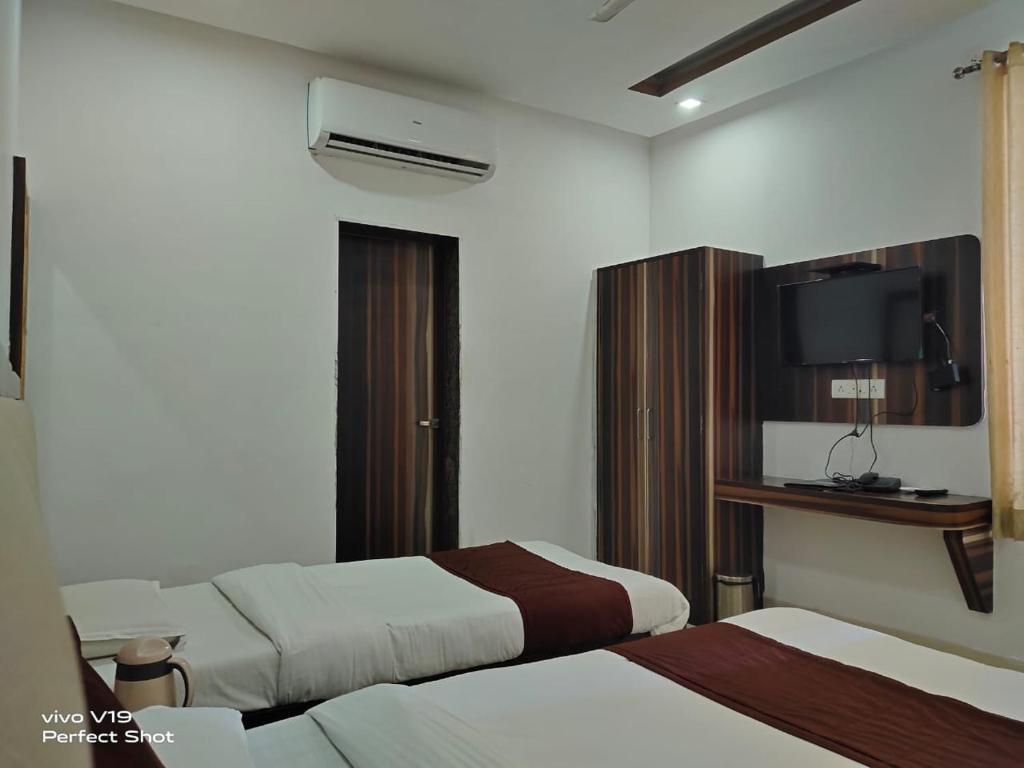 a hotel room with two beds and a tv at Hotel Royal Icon in Udaipur