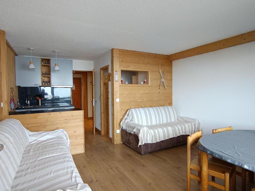 une chambre avec deux lits, une table et une cuisine dans l'établissement Appartement rénové proche des pistes avec parking et balcon - FR-1-445-150, à Montgenèvre