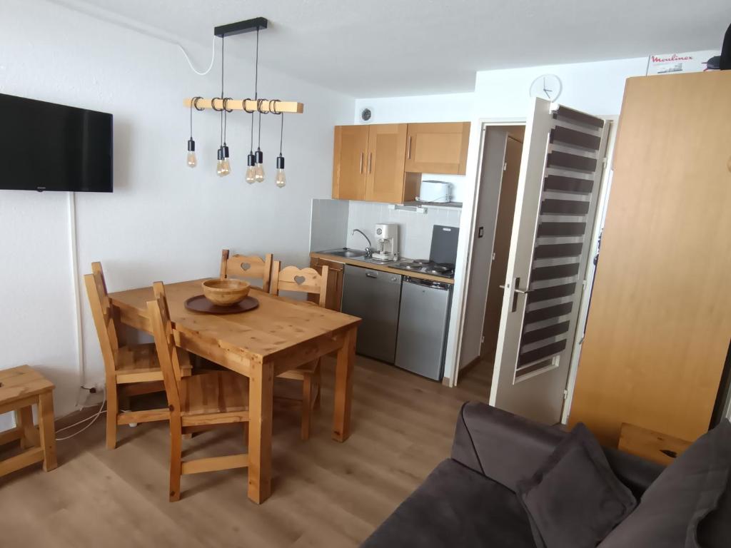 une cuisine et une salle à manger avec une table et des chaises dans l'établissement Appartement cosy rénové, sur les pistes, balcon, parking - FR-1-445-159, à Montgenèvre