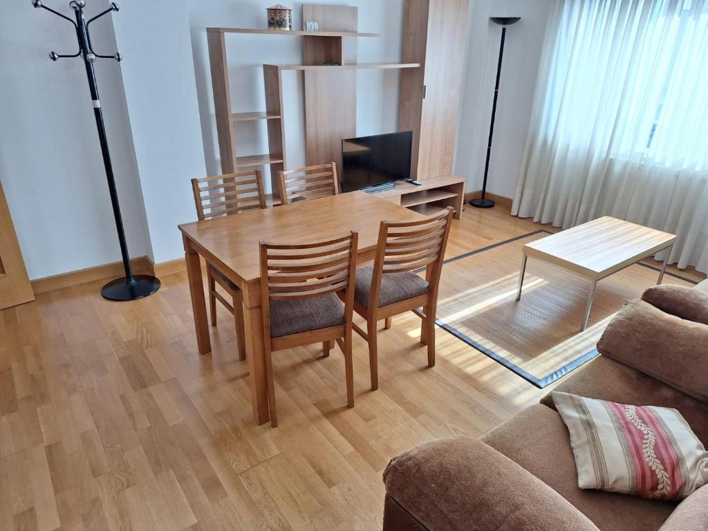 a dining room table and chairs in a living room at Apartamento Pose Arteixo in Arteixo