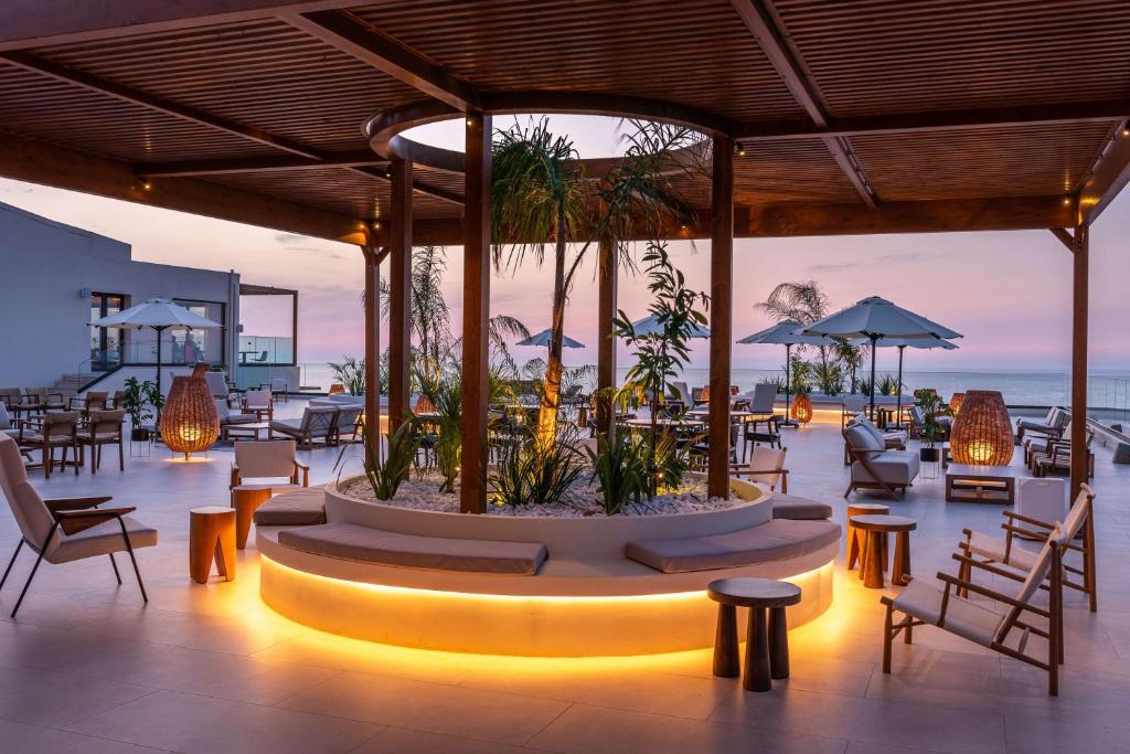 a restaurant with a large centerpiece with chairs and tables at Isla Brown Chania Resort, Curio Collection by Hilton in Stavros