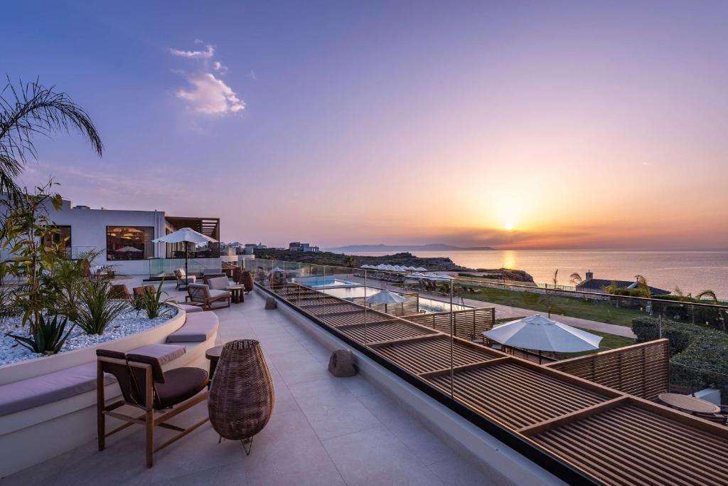 a resort with a view of the ocean at sunset at Isla Brown Chania Resort, Curio Collection by Hilton in Stavros
