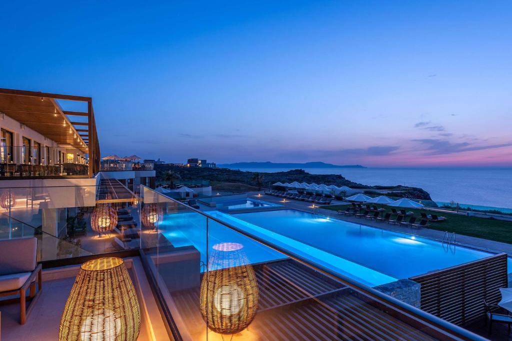 a view from the balcony of a hotel with a swimming pool at Isla Brown Chania Resort, Curio Collection by Hilton in Stavros