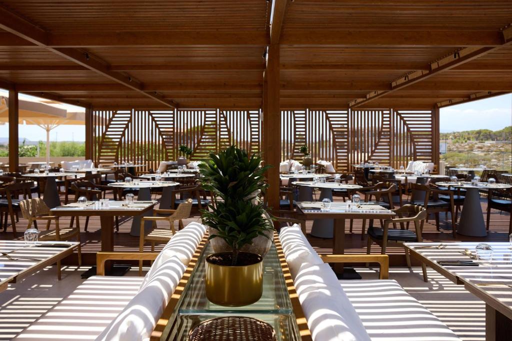 a dining room with tables and chairs and tablesearcher at Isla Brown Chania Resort, Curio Collection by Hilton in Stavros