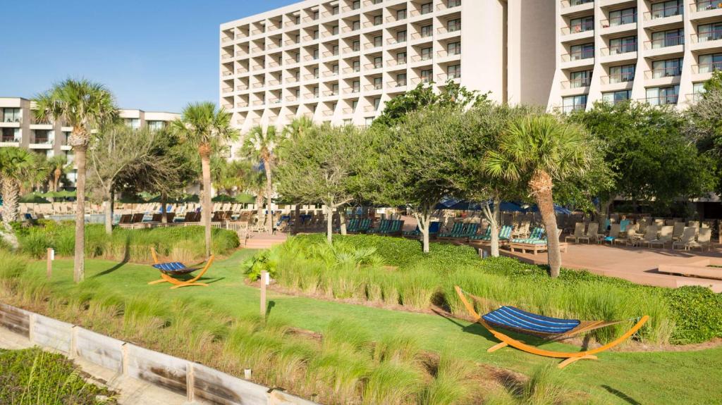 two hammocks in a park in front of a building at Hilton Beachfront Resort & Spa Hilton Head Island in Hilton Head Island