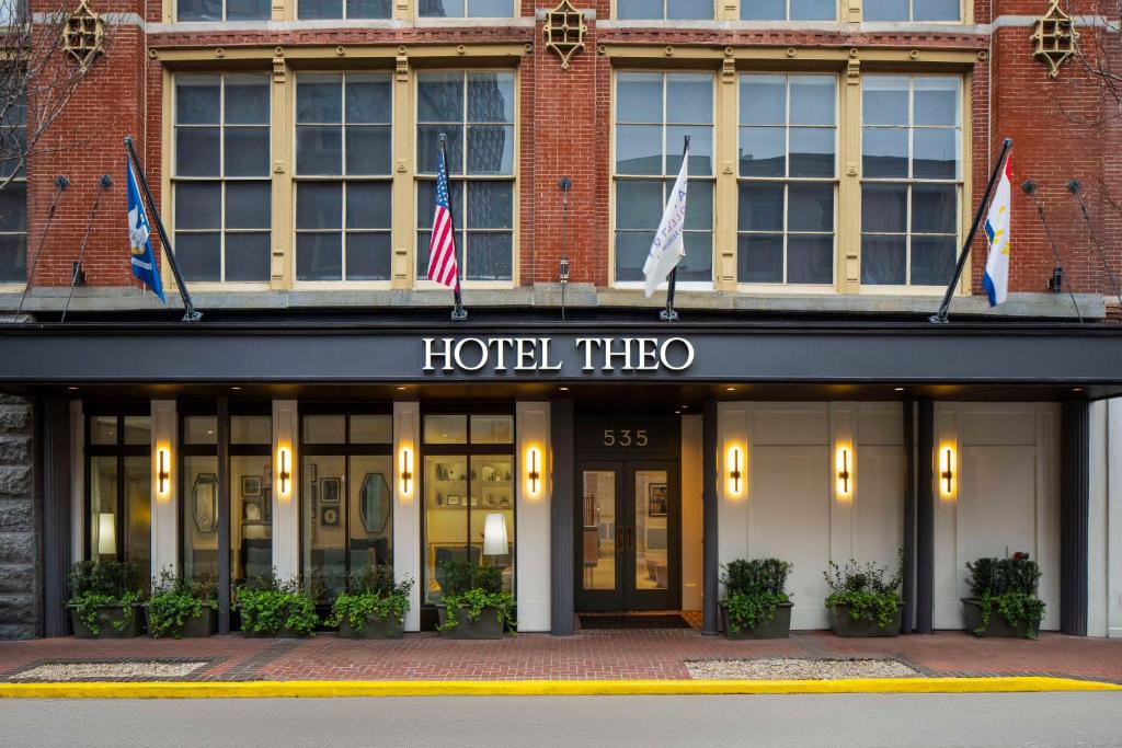 新奥尔良Hotel Theo New Orleans, Tapestry Collection by Hilton的大楼前方带有旗帜的酒店窗口