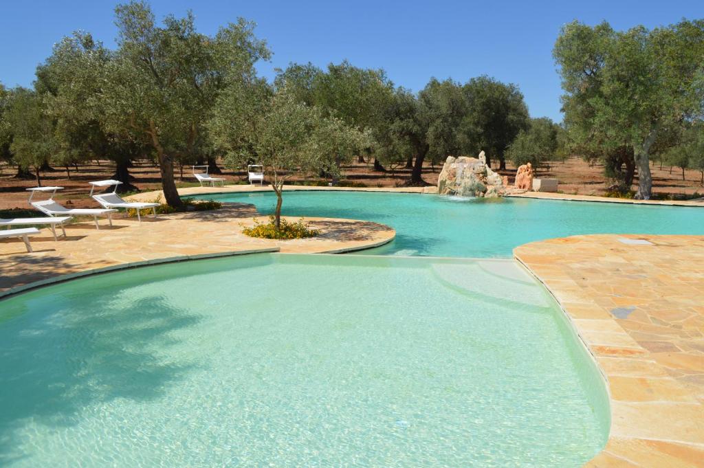 una grande piscina con fontana in un parco di Masseria Le Celline a Nardò